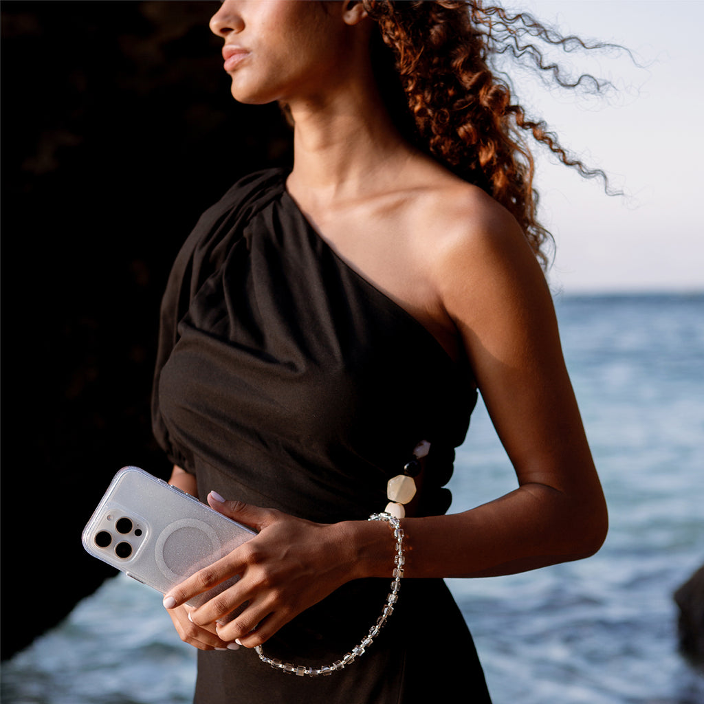 A model presenting LUMINO— the iPhone 16 Pro case with the phone wristlet, available in sparkling silver color