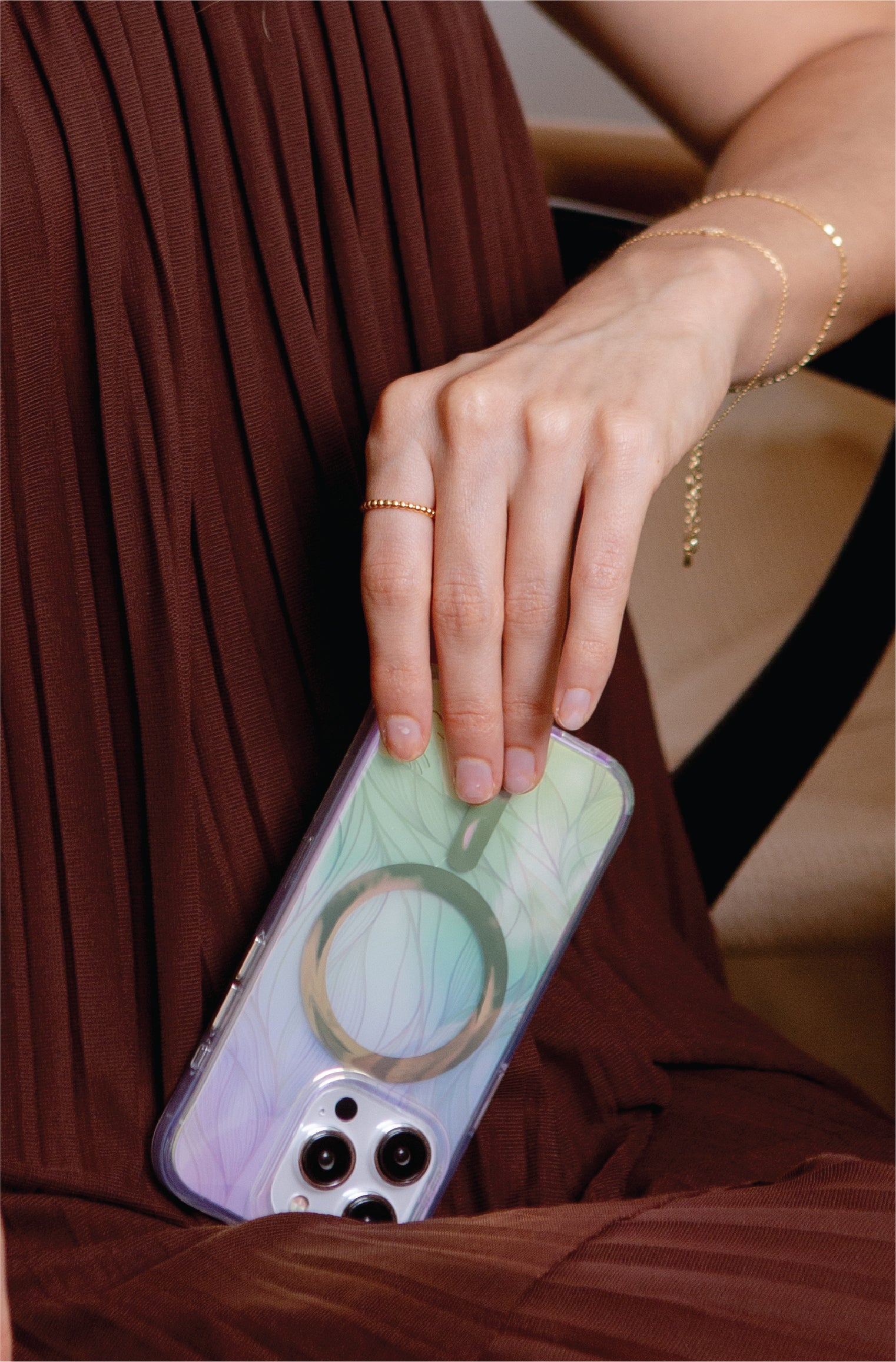 Hand with jewelry holding patterned phone